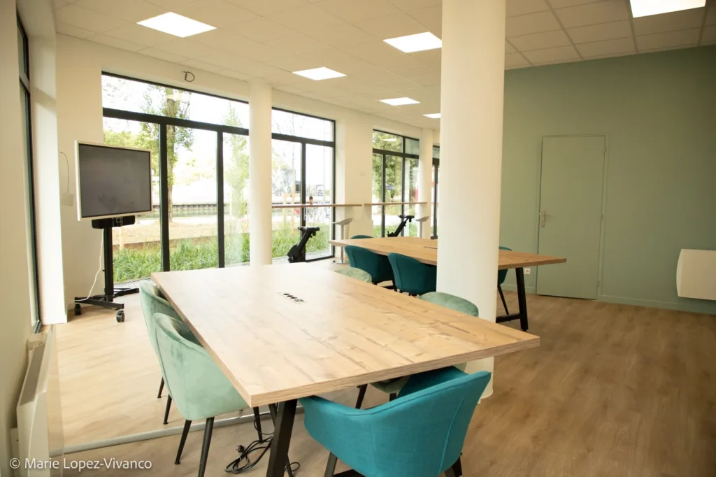 Grande table partagée dans l’espace de travail lumineux de La Coloc’